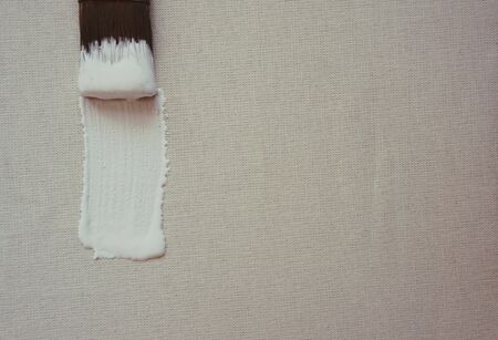 blank canvas and brush with white paint, primer with a place for inscriptionの写真素材