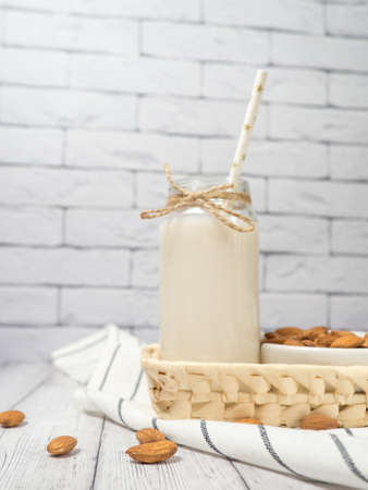 nuts almonds and almond milk on a white wooden tableの写真素材