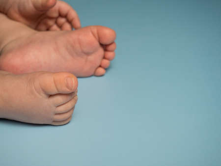 naked baby feet on a blue background, space for your text
