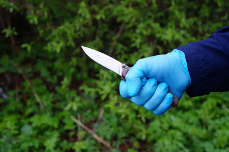 knife in the hand of a robber in a rubber glove, crime conceptの写真素材