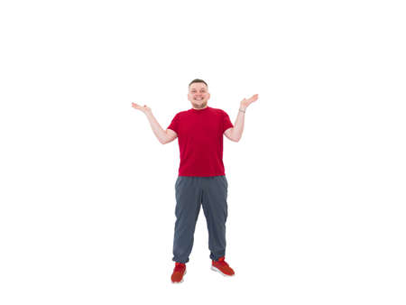 Portrait of a beautiful young guy in sports clothes, spread his hands and shows bewilderment and...