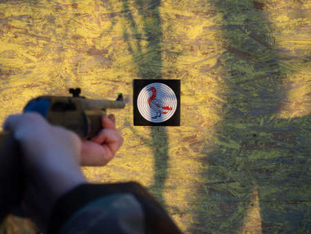 a man aims an air rifle at a target for shooting.