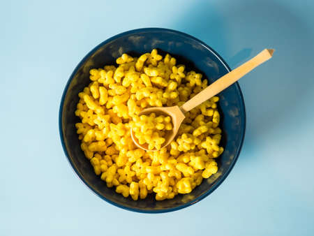 cornflakes stars, sweet cereal stars in a blue bowl on a blue background