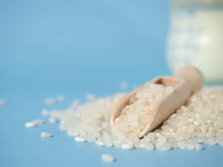 rice in a wooden spoon on the background of a baby bottle, baby milk rice drinking porridge .baby food concept, copy spaceの写真素材