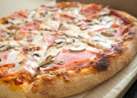 delicious pizza with ham and mushrooms close-upの写真素材