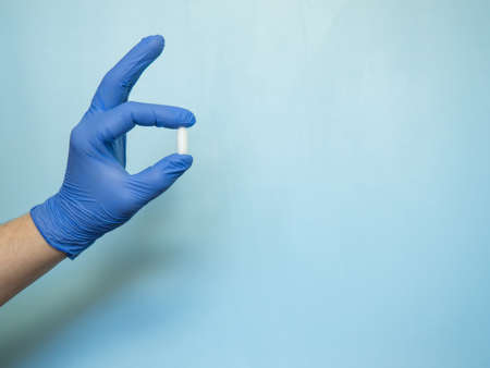 the rectal candle is held by a hand in a blue medical gloveの写真素材