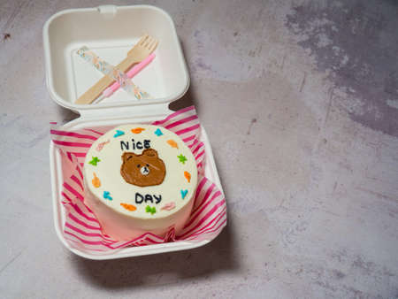 a small cake in a paper box with a fork and a candle, a holiday for two, a copy of the spaceの写真素材
