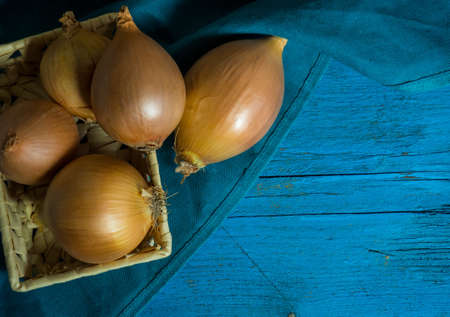 raw onions in the basket and on the table.copy spaceの写真素材