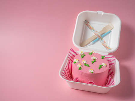 Korean lunch box cake with cream flowers in pink tones. place for your textの写真素材