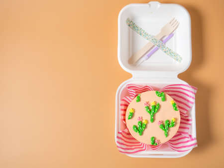 Orange cake for the holiday, decorated with colored cream cacti, a copy space