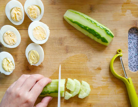 cutting vegetables for salad on a cutting wooden board