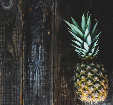 Fresh ripe pineapple on a wooden background with place for your text.の写真素材