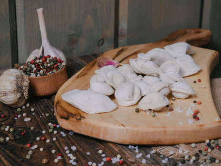 frozen semi-finished products-homemade dumplings on a rustic backgroundの写真素材