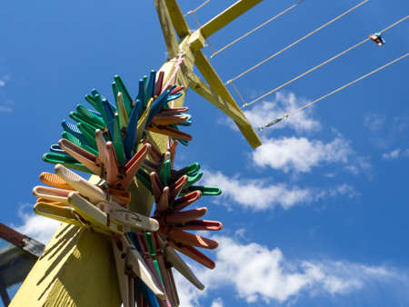 Many different colored plastic clothes pegs close up. Lots of clothespins