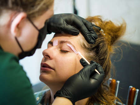 Makeup artist does facial hair removal procedure Melted wax for facial hair removal.
