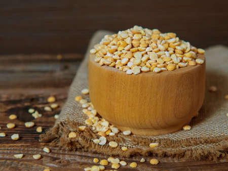 dry peas in a wooden bowl on an old wooden table close-up with copy spaceの写真素材