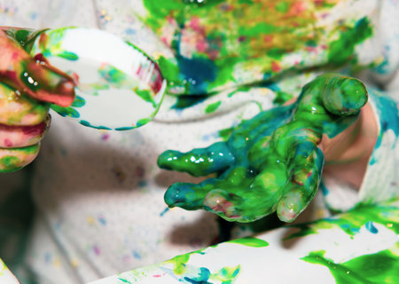 Finger coloring for kids. A little girl draws with paints with her hands on paper. Children development concept.の写真素材