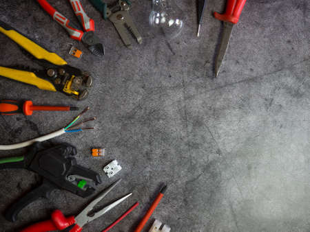 Flat lay composition with electrician's tools and space for text on gray concrete backgroundの写真素材