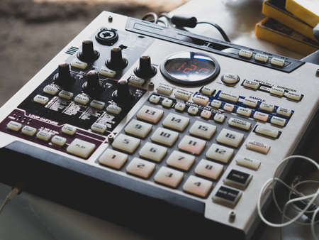 making hip hop beats on a drum machine controller and turntables in a home studioの写真素材