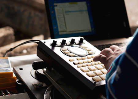 making hip hop beats on a drum machine controller and turntables in a home studioの写真素材