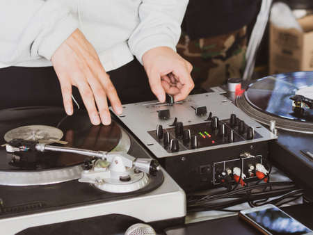 DJ playing music at a hip hop party. analog turntable, Dj uses turntable and mixer for scratching.の写真素材