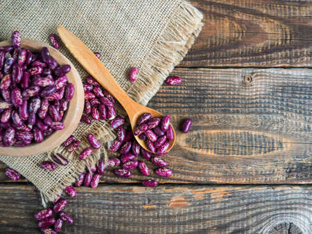 red beans with a pattern. (Delicious variegated, raw common beans) in a wooden spoon close-up on an...