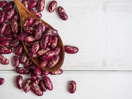 red beans close-up on a wooden spoon on a white wooden table, copy spaceの写真素材