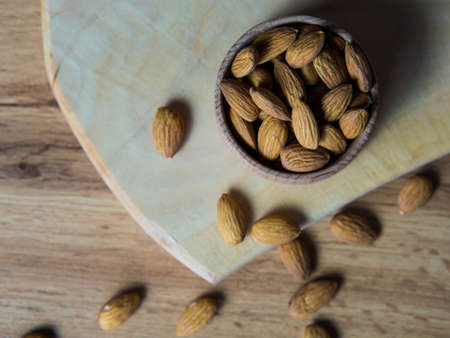 Bowl with delicious almonds on a wooden tableの写真素材