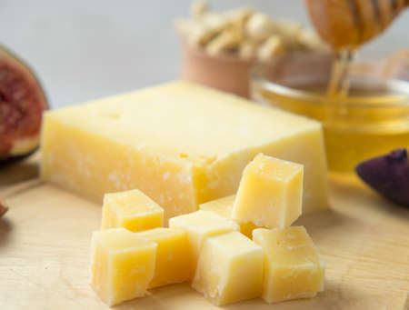 Pieces of aged cheese, nuts, figs and honey on a cutting board,の写真素材