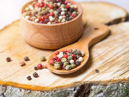 Pepper mix. Black, red, green, white peppercorns spices, Mix of different peppers in a wooden spoonの写真素材