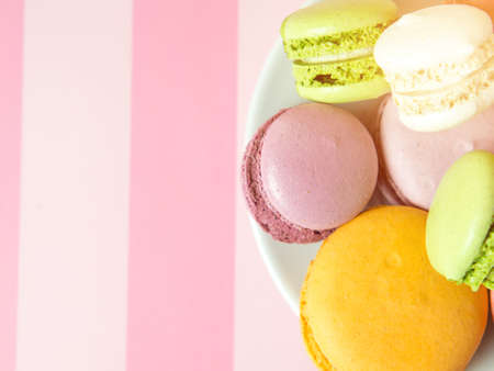Fresh baked colored macaroon cookies macarons, macarons on a white plate close-up,の写真素材
