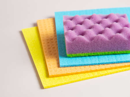 Cleaning sponges and rags on purple background
