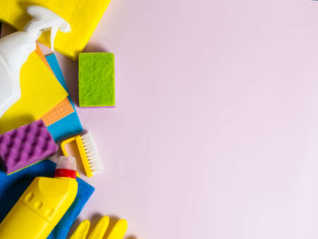colorful home cleaning tools gels. sponges. rags on purple background copy space