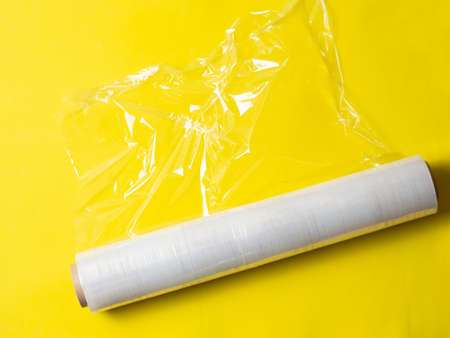 roll of wrapping stretch film for packaging on yellow background isolatedの写真素材