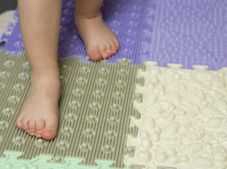 baby's feet on a children's orthopedic mat close-upの写真素材