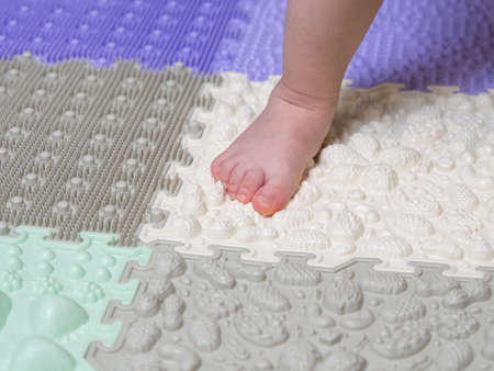 baby's feet on a children's orthopedic mat close-upの写真素材