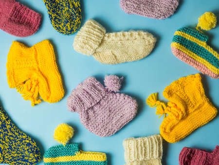 Baby socks on a blue background. Knitted warm baby clothes. Multicolored socks for girls and boys.の写真素材