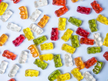 Delicious bright gummy bears on a blue background, flat layの写真素材