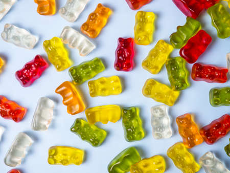 Delicious bright gummy bears on a blue background, flat layの写真素材