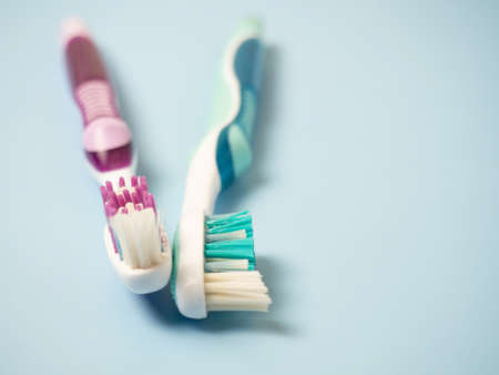 old toothbrushes on a blue background .used male and female toothbrushesの写真素材