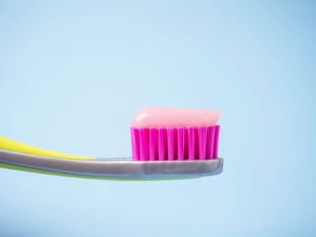 Toothbrush with pink toothpaste. Close up of pink toothpaste on a toothbrush.の写真素材