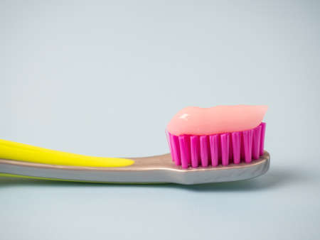 Toothbrush with pink toothpaste. Close up of pink toothpaste on a toothbrush.の写真素材