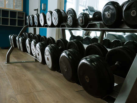 Rows of dumbbells in the gym. Rack with heavy dumbbells in a fitness club. Workout bodybuilding...