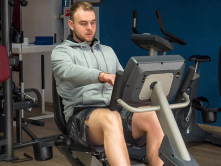guy on an exercise bike in the gym. Fitness, workout and healthy lifestyle