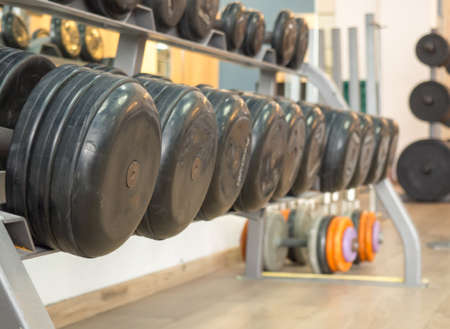 Rows of dumbbells in the gym. Rack with heavy dumbbells in a fitness club. Workout bodybuilding concept.の写真素材