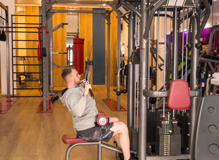 the guy goes in for sports on a simulator in a fitness club, the guy pumps muscles