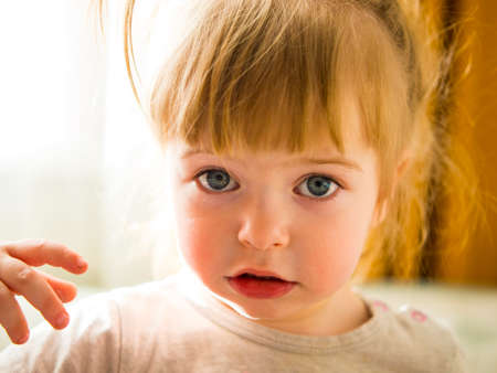 close-up portrait of a beautiful blue-eyed little girlの写真素材