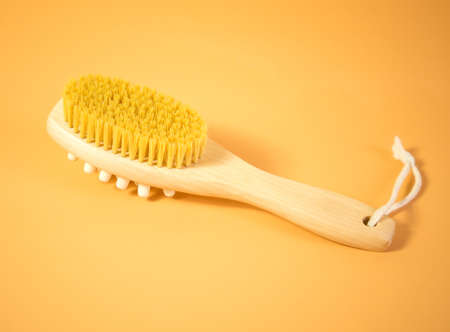 On an orange background, accessories for spa treatments, brushes for face and body massageの写真素材