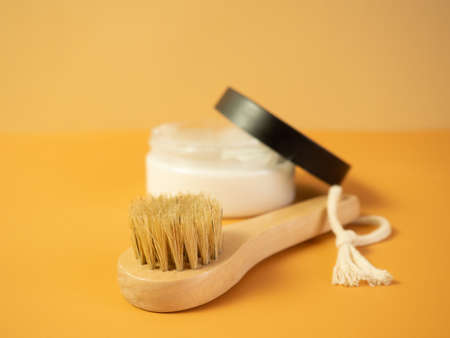 On an orange background, accessories for spa treatments, brushes for face and body massageの写真素材
