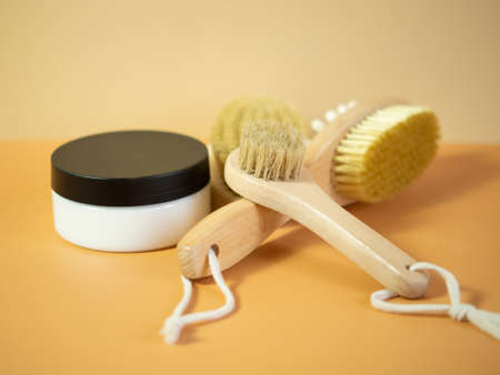 On an orange background, accessories for spa treatments, brushes for face and body massageの写真素材